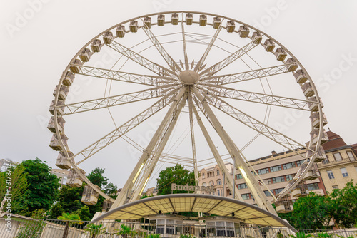 Big, tall white Ferris wheel in front of a perfect blue sky. Happy summer vacation feelings.