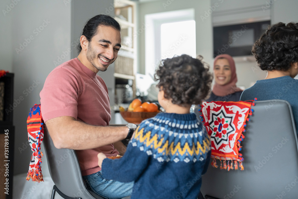 Obraz premium Family with sons (2-3, 6-7) sitting at table at home