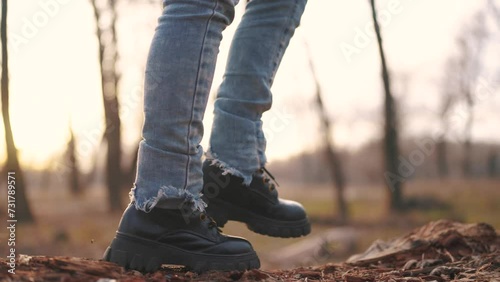 boy play in a forest park. A close-up of a child's feet walking along a log of a fallen tree lifestyle. happy family child dream concept. girl child in sneakers walks on a fallen tree in a park photo