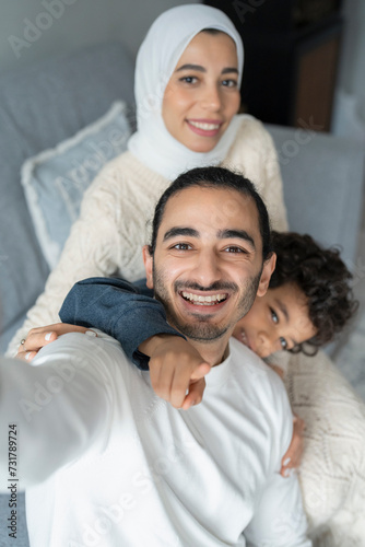 Photography Portrait of parents and son (6-7) taking selfie at home