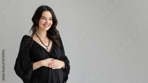 Brunette pregnant woman with pregnancy belly, in soft black clothes