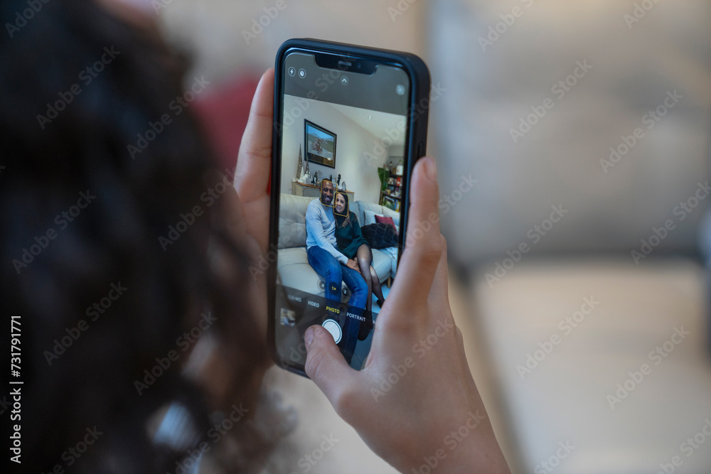Close-up of girl photographing parents with smart phone