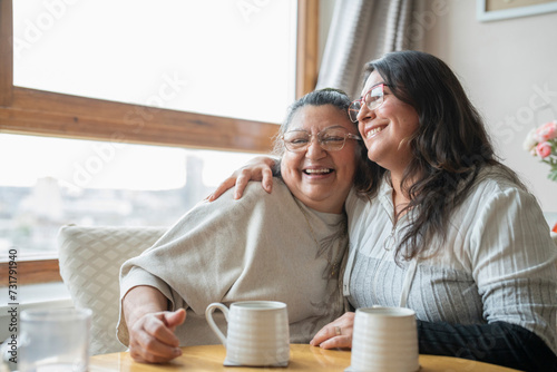 Foto Senior mother and mature daughter hugging at home