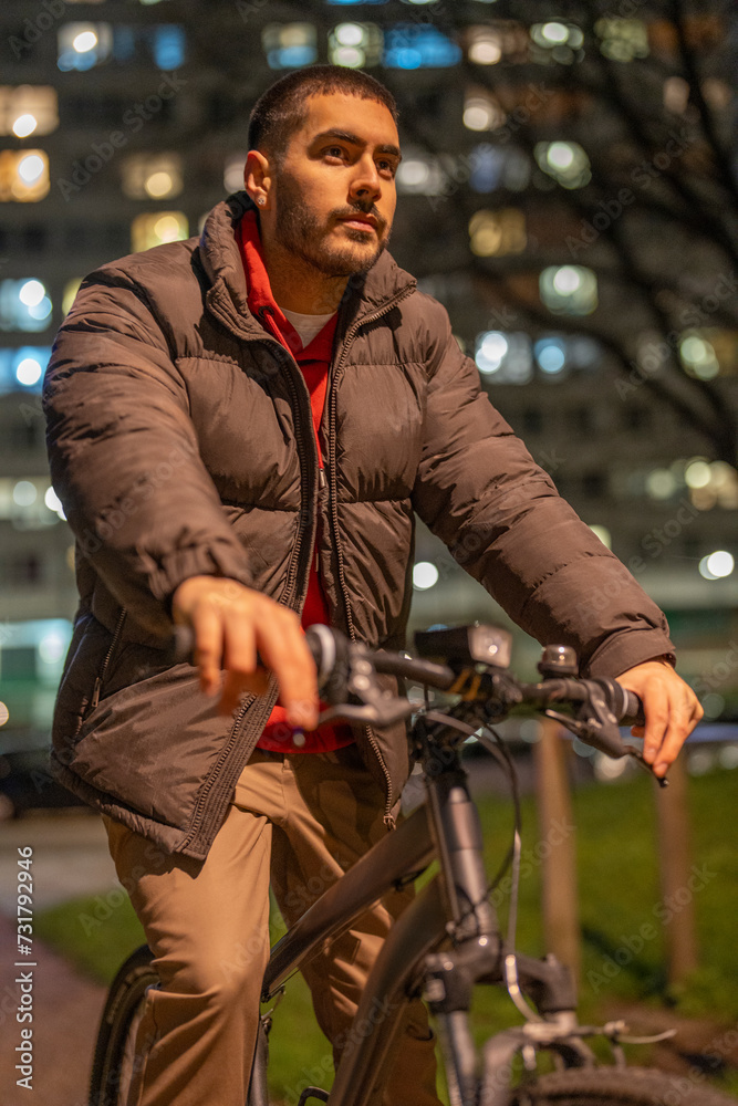 Young man riding bicycle at night