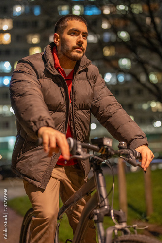 Young man riding bicycle at night © Cultura Creative