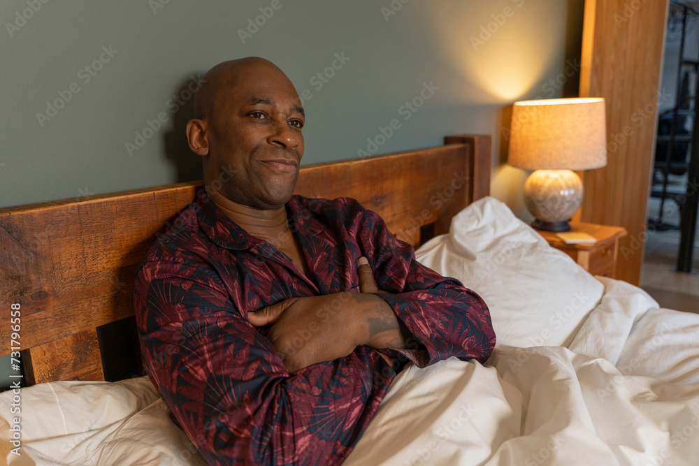 Fototapeta premium Man relaxing while lying in bed in morning