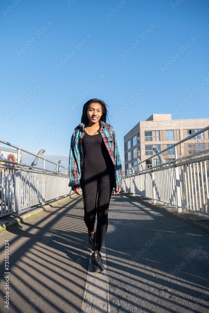 Portrait of smiling woman walking on footbridge