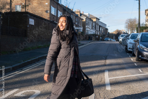 Photos Portrait of smiling woman in long overcoat crossing street