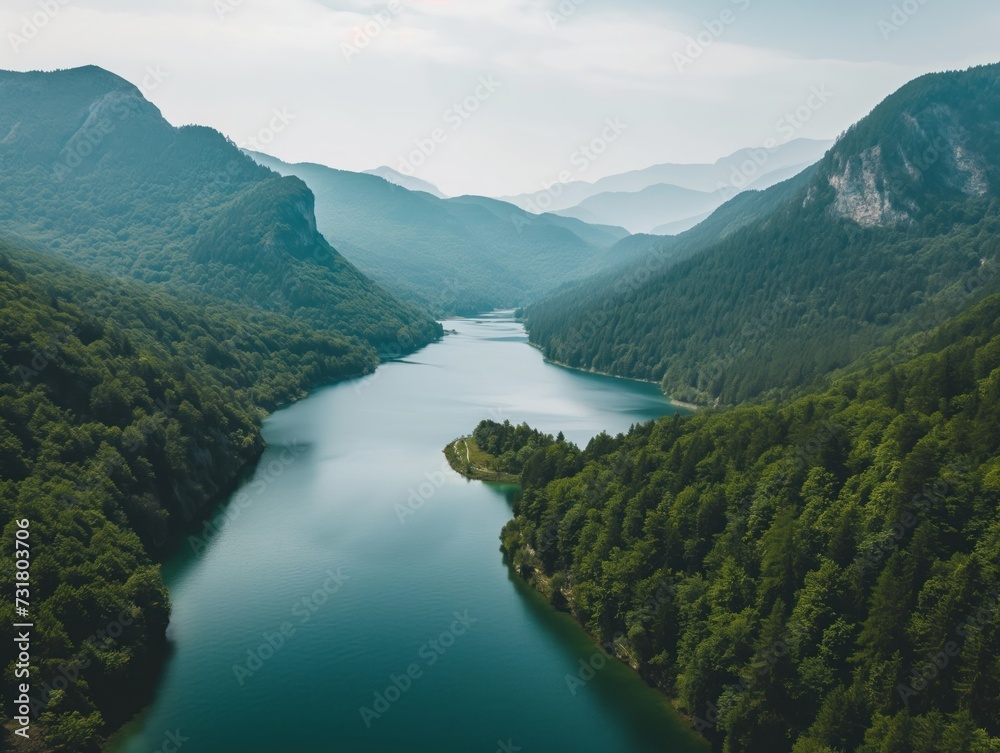 Aerial view of a serene lake surrounded by mountains and forests