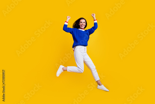 Full length body photo of successful brunette woman raise fists up celebrate new collection clothes isolated on yellow color background