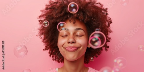 Happy Girl Blows Soap Bubbles On Pink Background, Showcasing Her Curly Hair. Сoncept Curly Hair, Soap Bubbles, Pink Background, Happy Girl, Outdoor Photoshoot