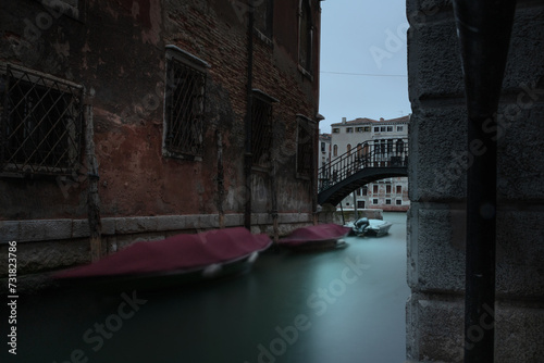 Particolare di Venezia: un rio che sbocca nel Canal Grande e le barche ormeggiate lungo il canale photo