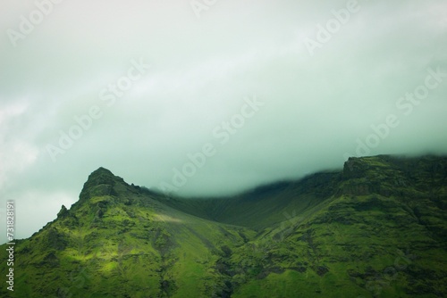 Majestic mountain with lush green foliage rises high into the sky, Iceland