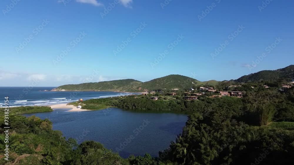 Drone view over the Praia do Rosa beach surrounded by green vegetation Drone view over the Praia do Rosa beach surrounded by green vegetation
