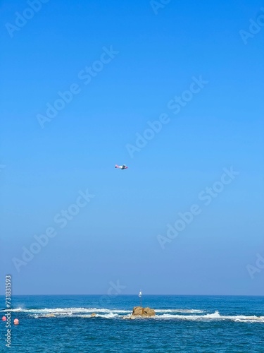 plane taking off from the ocean with people swimming in the ocean
