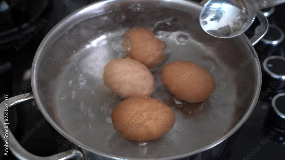The eggs are cooking in a pot in boiling water. Cooking of brown chicken eggs. Metal saucepan on a gas stove. Healthy eating. A dietary product. Close-up. Fast breakfast food. Slow motion 4K footage. The eggs are cooking in a pot in boiling water. Cooking of brown chicken eggs. Metal saucepan on a gas stove. Healthy eating. A dietary product. Close-up. Fast breakfast food. Slow motion 4K footage.
