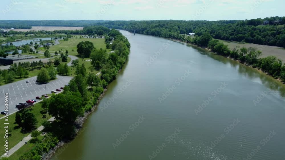 Aerial of a wide calm river with a bridge in the background during the daytime Aerial of a wide calm river with a bridge in the background during the daytime