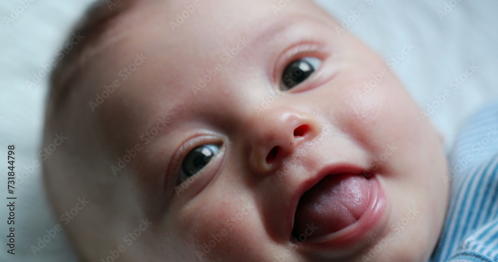 Happy newborn baby infant face closeup of expression Happy newborn baby infant face closeup of expression