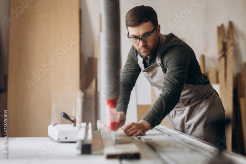 Carpenter working with wood and saw in the manufacturing industry photo