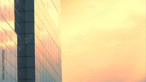 Office builiding, exterior view on the sky background with colorful yellow and orange clouds, sun, light, estate, city, work, tower, place, center, day, close up, static shot, time lapse. ProRes 422HQ photo