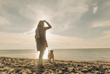 woman playing with majorca mastiff dog on the beach