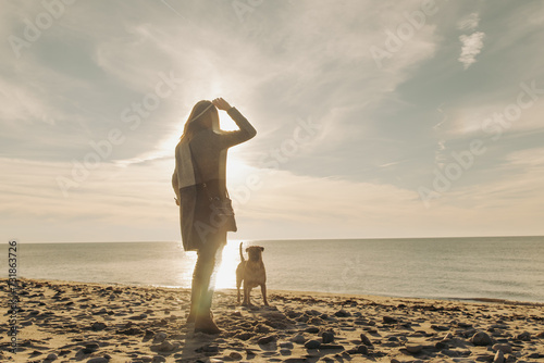 woman playing with majorca mastiff dog on the beach photo