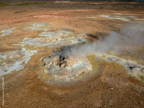 Inside a big crater of an active volcano with gray-white smoke coming out, aerial view. Earth, nature, and environment concepts.