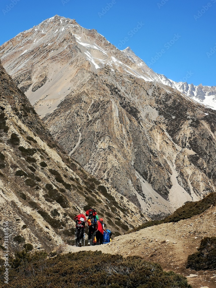 A group of adventurous people walking on top of a mountain