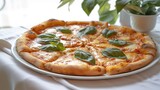 Delicious pizza Margherita with basil served on a white plate on a table with a white tablecloth