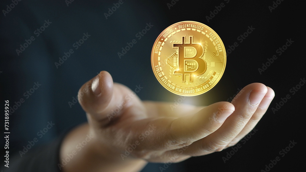 Businessman's hand has a coin Bitcoin,Buying and investing in BTC crypto-currency.Digital Cryptocurrency. Businessman's hand has a coin Bitcoin,Buying and investing in BTC crypto-currency.Digital Cryptocurrency.