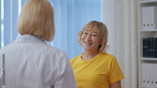 A patient and her rehabilitation therapist finish a session, having a pleasant conversation
