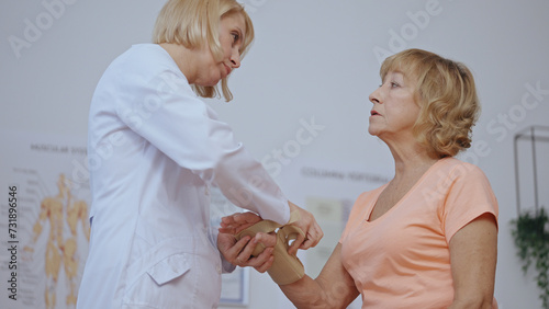 A traumatologist removes a cast from a patient's arm, revealing a healed hand, signifying recovery photo