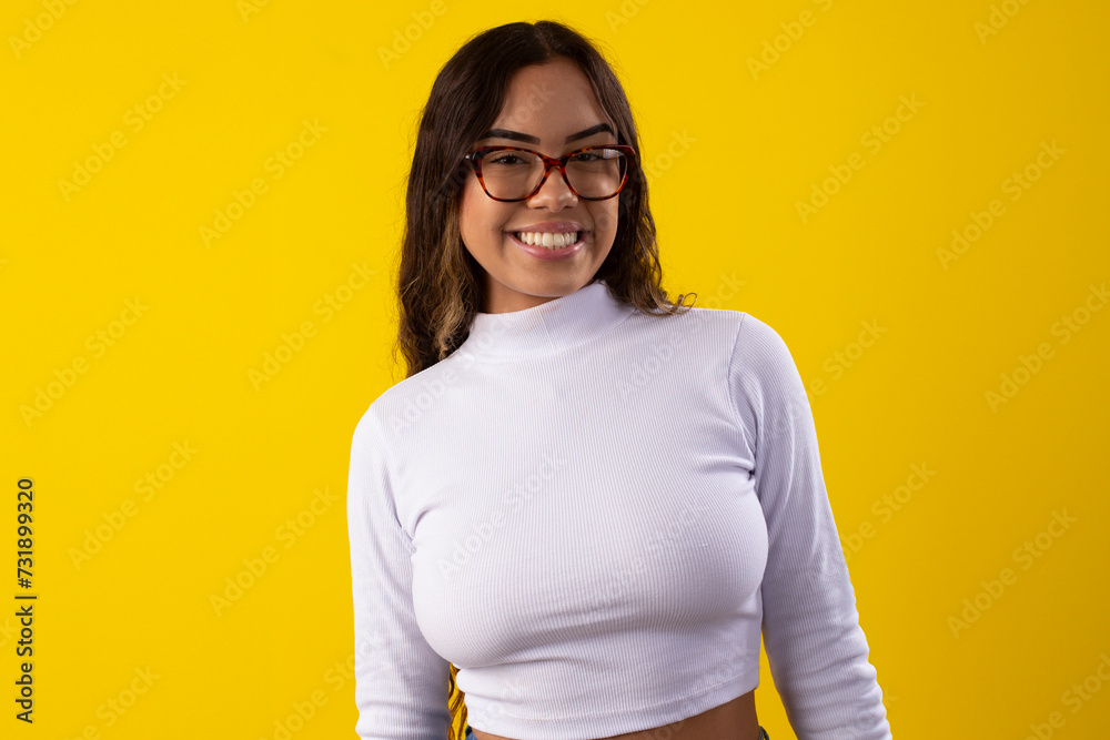 Happy young woman wearing glasses and a white blouse, happy on yellow background Happy young woman wearing glasses and a white blouse, happy on yellow background