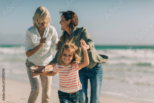 Three generations of women having fun on the beach photo