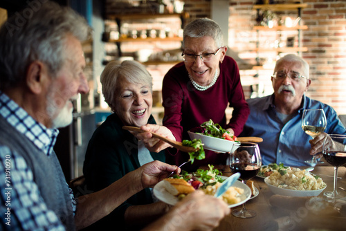 Happy senior people eating dinner together at home