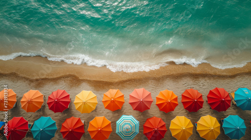 Colorful parasols by the sea from above