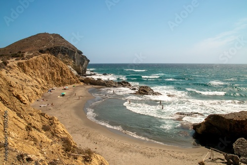 Bañistas en la cala de Los Amarillos en el mar Mediterráneio. Pequeña playa junto a la playa de los Genoveses a finales de verano. Níjar, España.
