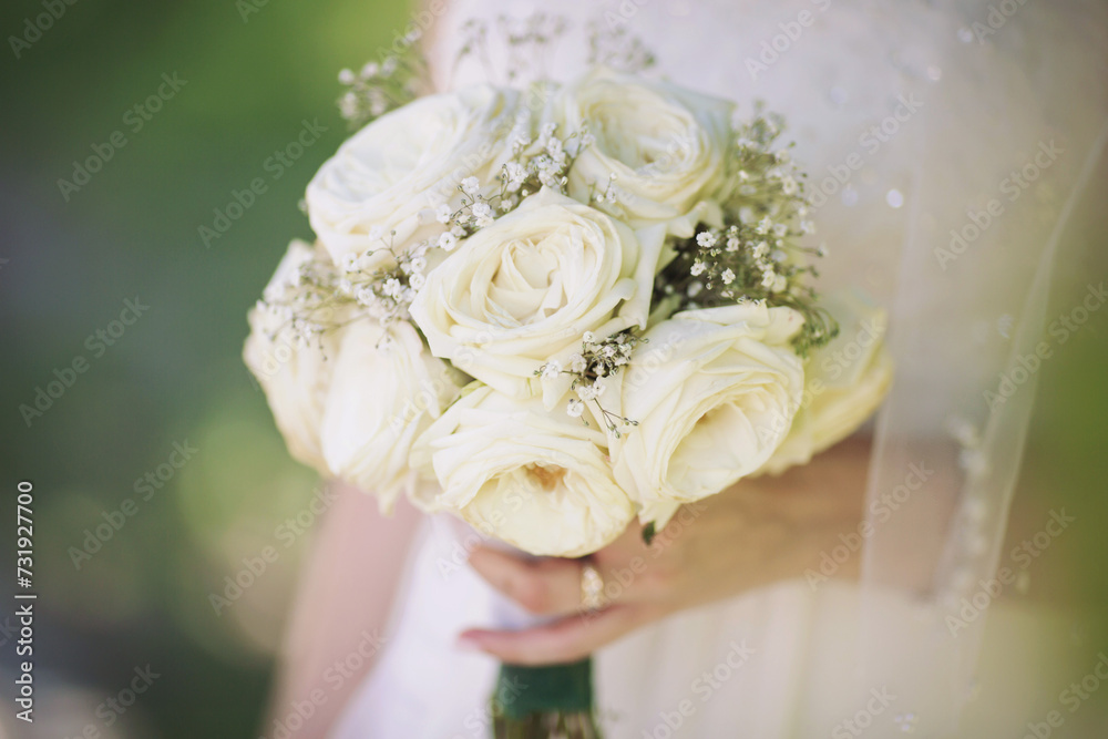 Obraz premium wedding bouquet in bride's hands. beautiful tender wedding bouquet of white roses flowers in hands of the bride. 