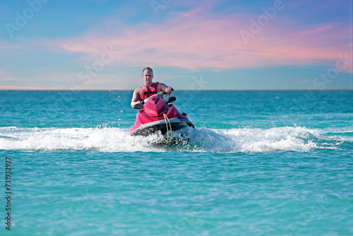 Young guy cruising on the caribbean sea on a jet ski © Nataraj