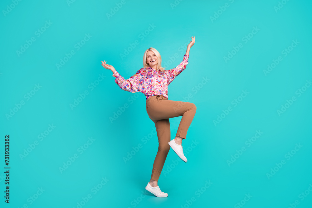 Full length photo of excited funky lady wear print blouse walking dancing isolated teal color background