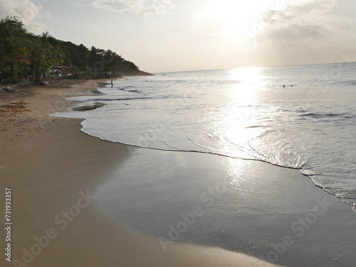 late afternoon in the beach in Deshaies  people swimming in the background