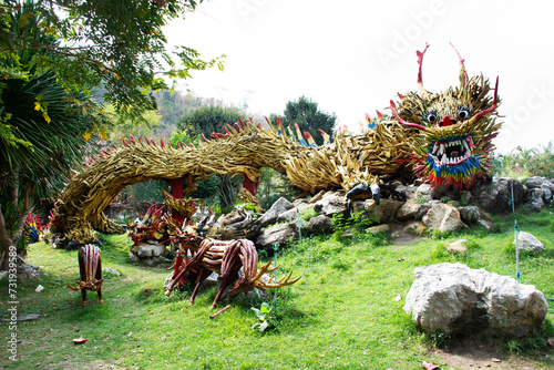 Art sculpture carving wooden chinese ancient dragon and wood antique snake naga gardening in garden park for thai people travel visit of Wat Tham Khao Prathun Temple at Banrai in Uthai Thani, Thailand