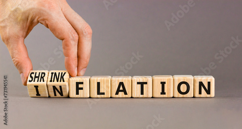Inflation or shrinkflation symbol. Concept words Inflation Shrinkflation on beautiful wooden blocks. Beautiful grey background. Businessman hand. Business inflation shrinkflation concept. Copy space