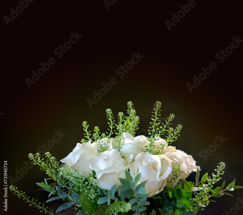 White roses with green leaves isolated on black background .