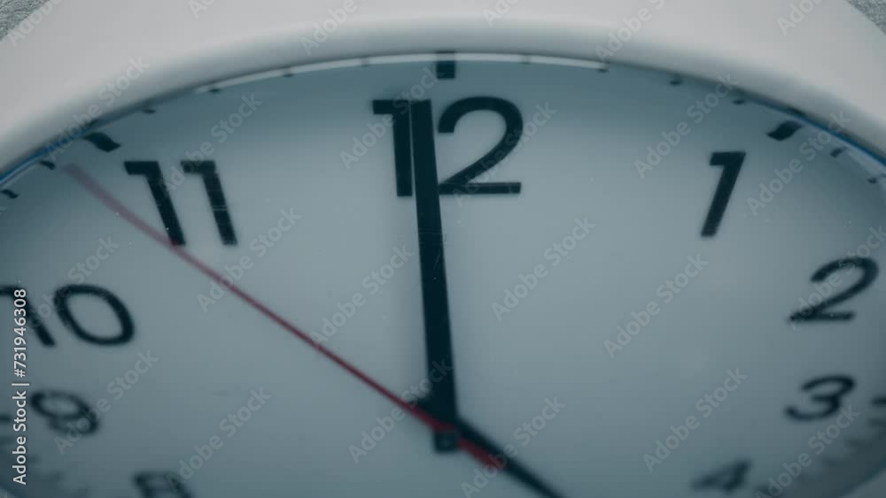 Cinematic High-angle Close-up Shot of White Office Wall Clock with Red Second Hand that Counting Down the Seconds to Twelve. Concept: Anticipation, Deadline, Tension and Passage of time Cinematic High-angle Close-up Shot of White Office Wall Clock with Red Second Hand that Counting Down the Seconds to Twelve. Concept: Anticipation, Deadline, Tension and Passage of time