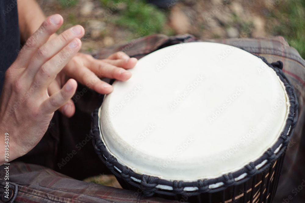 Person playing a traditional African djembe drum with hands close up Person playing a traditional African djembe drum with hands close up