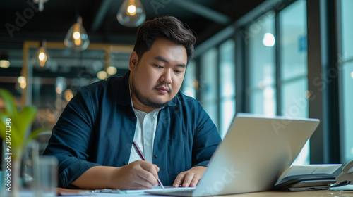 Plus size manager asian businessman CEO working on desk with computer laptop in modern office