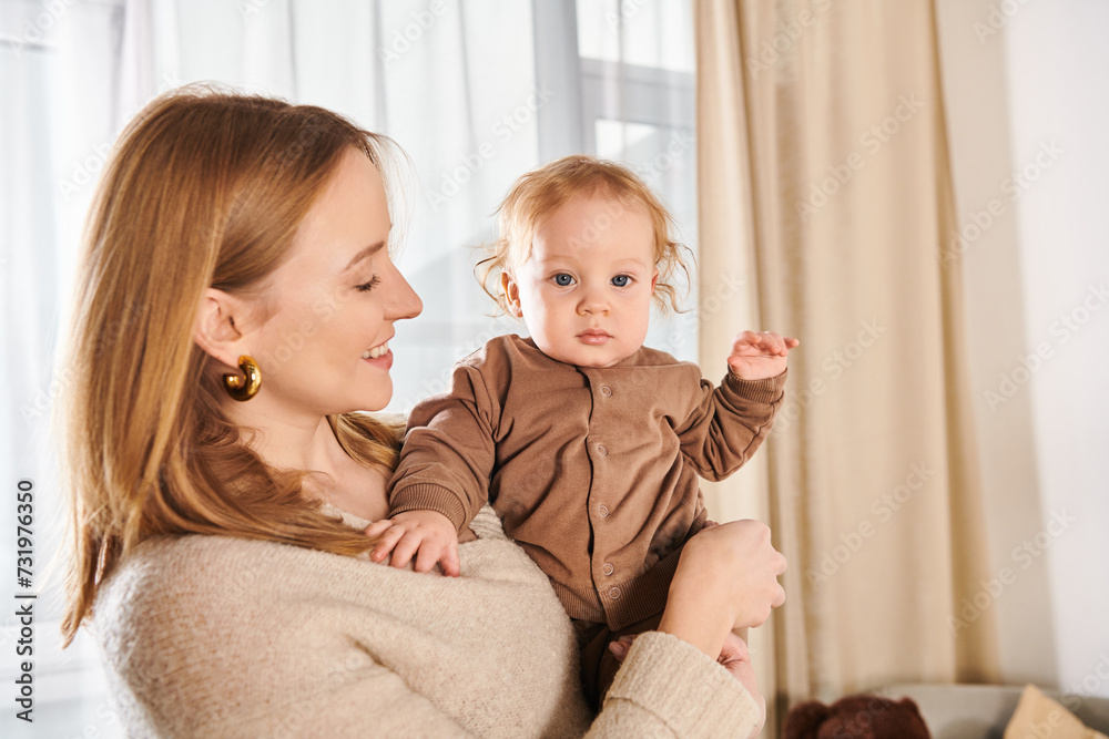 joyful woman holding little baby boy in hands in nursery room at home, blissful motherhood joyful woman holding little baby boy in hands in nursery room at home, blissful motherhood