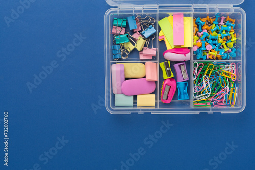 Colorful stationery in organizer on color background, top view