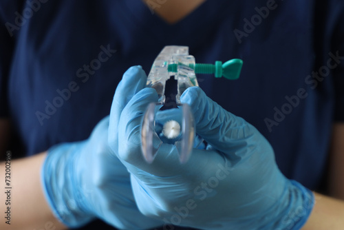 Professional holding a dilator for papanicolau exam in the hands point to the camera photo